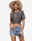 Leopard mesh sheer crew neck blouse with knot front and short sleeves.