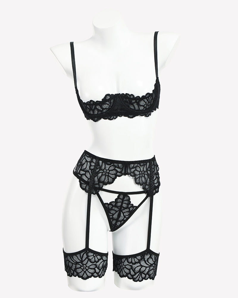 Black lace lingerie set on mannequin: lace bralette, garter belt, and thigh garters