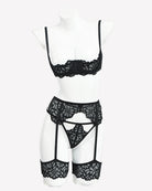 Black lace lingerie set on mannequin: lace bralette, garter belt, and thigh garters