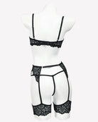 Black lace lingerie set on mannequin with strappy garter belt and high-cut panties