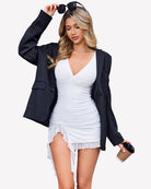Ruched bodycon mini dress in white, deep V neck, asymmetrical ruffle hem and slit