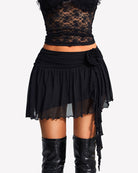 Black tulle mini skirt with layered ruffle hem and draped side tie strings