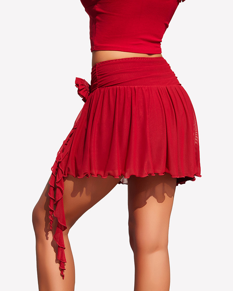 Red mesh mini skirt with ruched waist, asym hem, and rosette side flower with tassels.