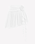 White mesh mini skirt with ruched waistband, layered ruffle hem and large flower accent