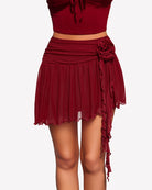 Wine red mesh mini skirt with flower detail at the side and fluttering asymmetric ties