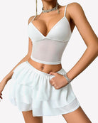 White two-piece lounge set with triangle V-neck cami top and layered mini skirt