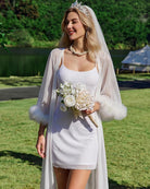 White spaghetti strap mini dress with sheer draped overlay and feather trim