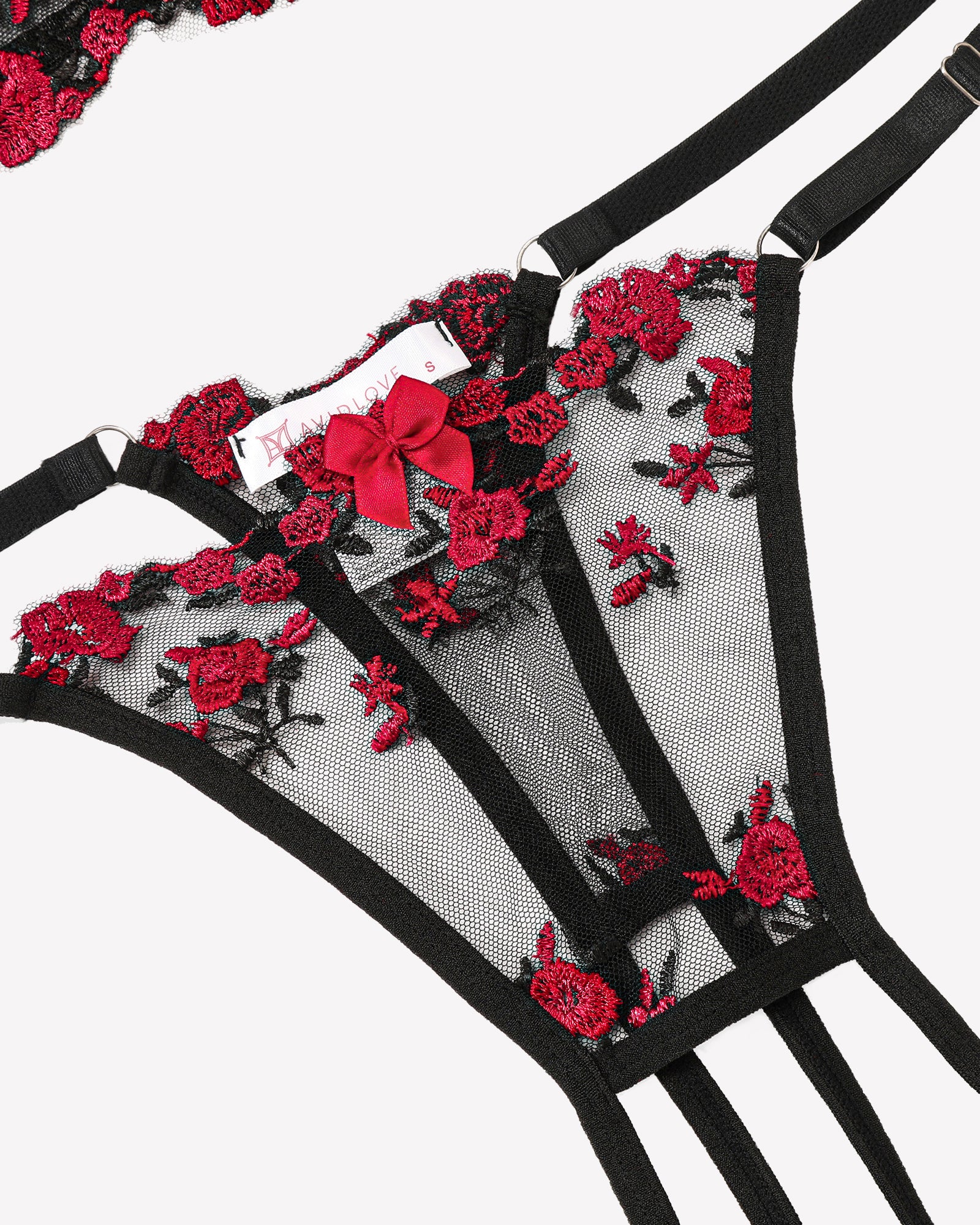 Sheer lace underwire bra with black straps and red floral embroidery, close-up