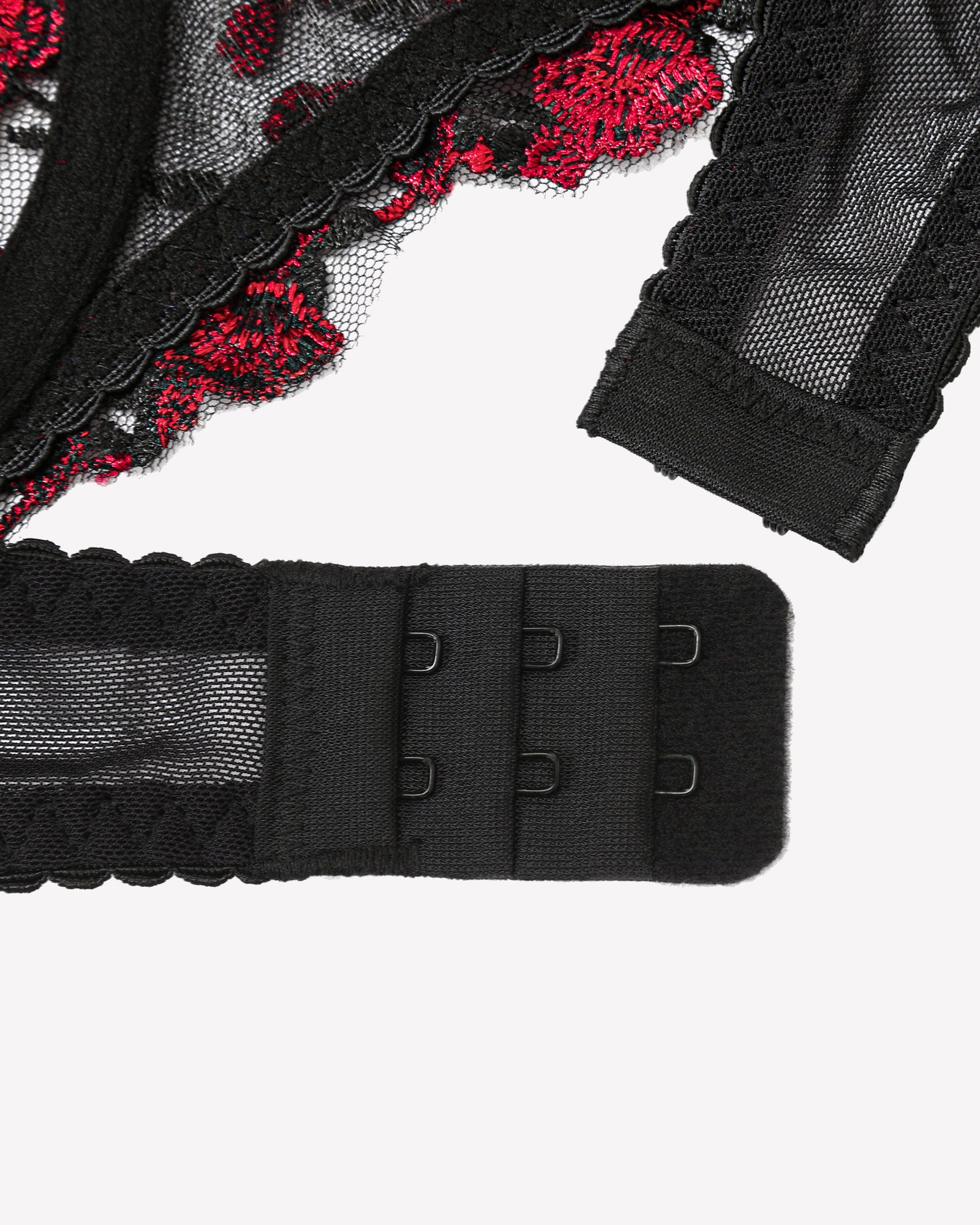 Black bra back band with adjustable hooks, red floral lace trim, close-up