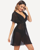 Black swimsuit cover up with V-neck, tie belt, sheer fabric, pom-pom tassel hem