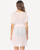 White sheer swimsuit cover up, back view with tie waist and pom-pom tassel trim