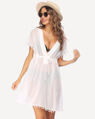 White sheer swimsuit cover up with V-neck, tie waist, flutter sleeves and pom-pom hem