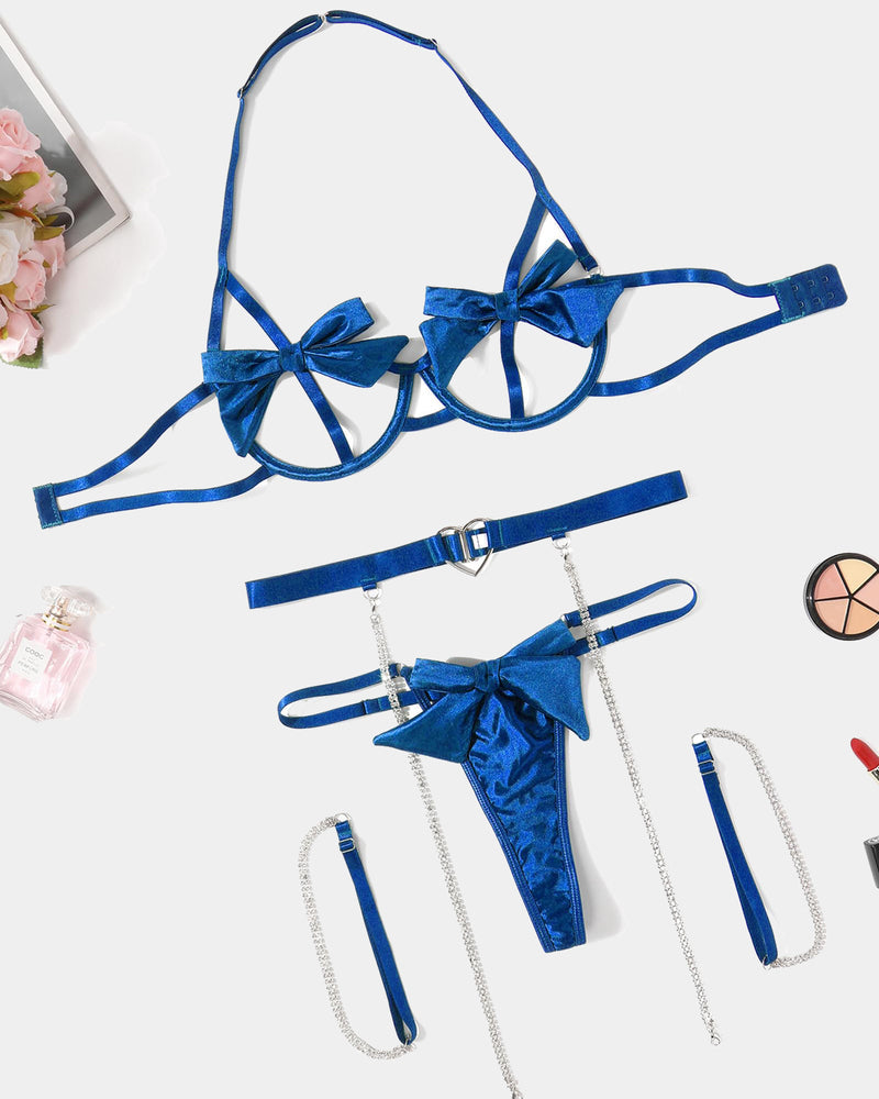 Blue bow lingerie set flat lay: bra, belt, thong, and chain garters