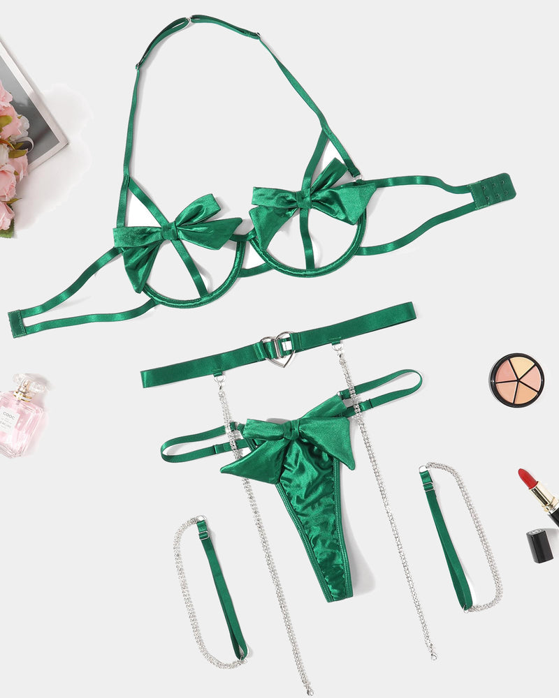 Green bow lingerie set flat lay: bra, belt, thong, and chain garters