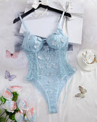 Light blue floral lace sheer mesh snap bodysuit hanging on black hangers