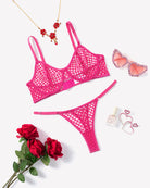 Hot pink fishnet hollow-out push-up bra and thong set, flat lay