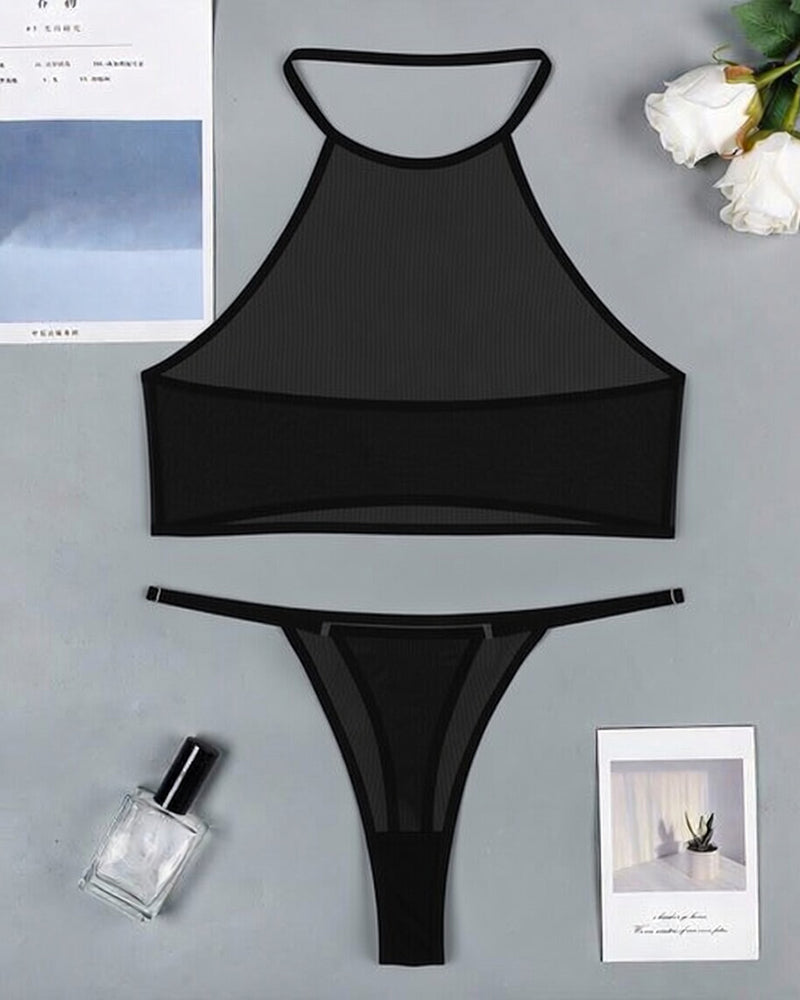 Sheer halter crop top and thong set with black trim, flat lay