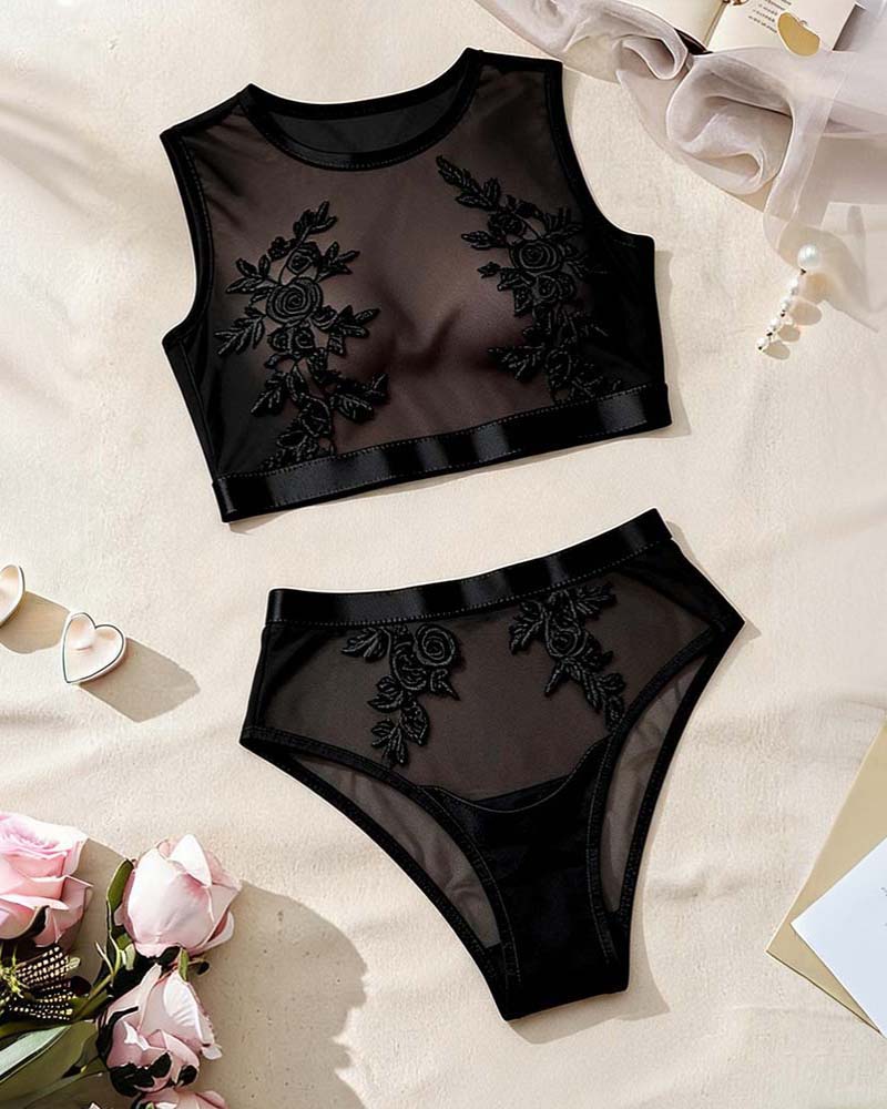 Black floral embroidered mesh bralette and matching sheer panty, laid flat