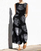 Black printed sleeveless jumpsuit with elastic waist and abstract swirl pattern