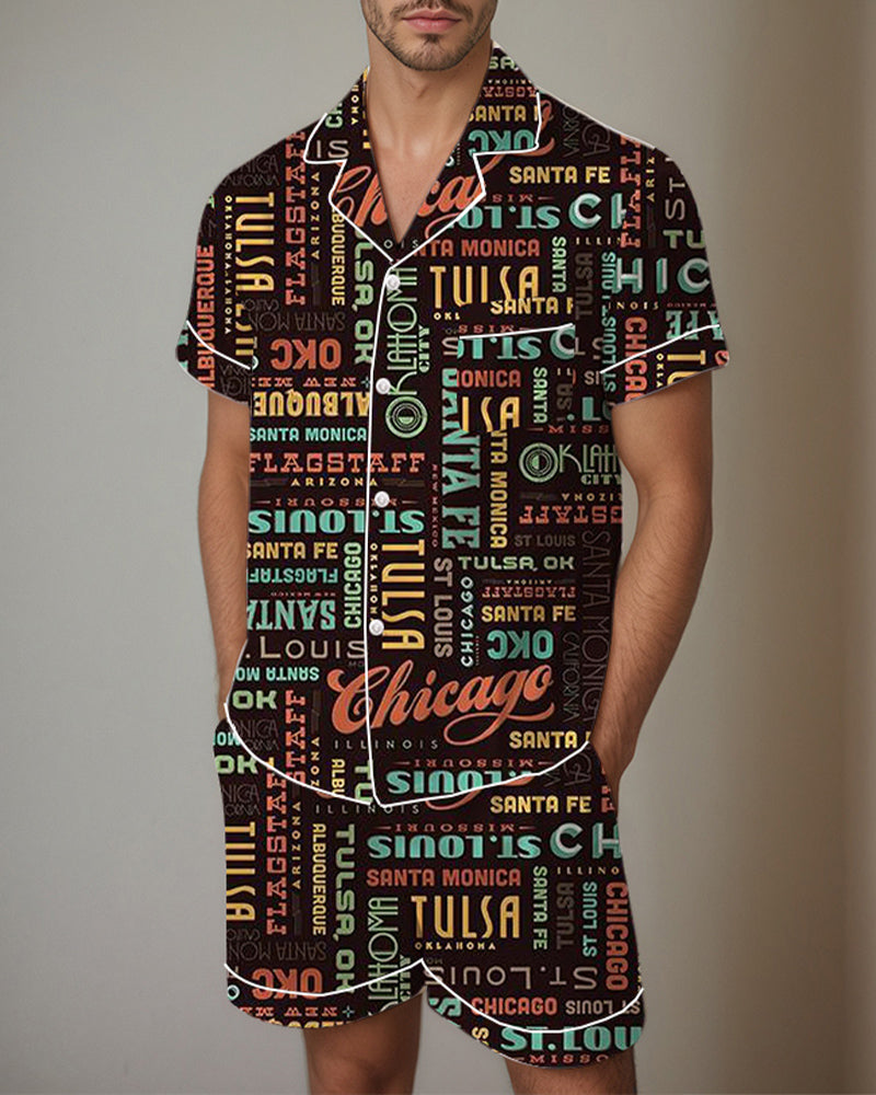 Men’s satin pajama set with dark graffiti-style lettering pattern, short-sleeve button shirt and shorts