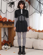 Black gothic mini dress with corset lacing, striped tights, and lace-up boots