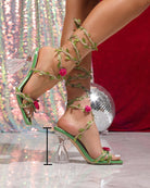 Light green lace-up clear-heel sandals with floral vine ankle straps and pink rose accents