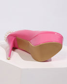 Pink patent platform heel shoe with pearl anklet chain, side view close-up