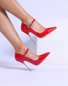 Red patent stiletto pumps with rhinestone buckle strap and pointed toe
