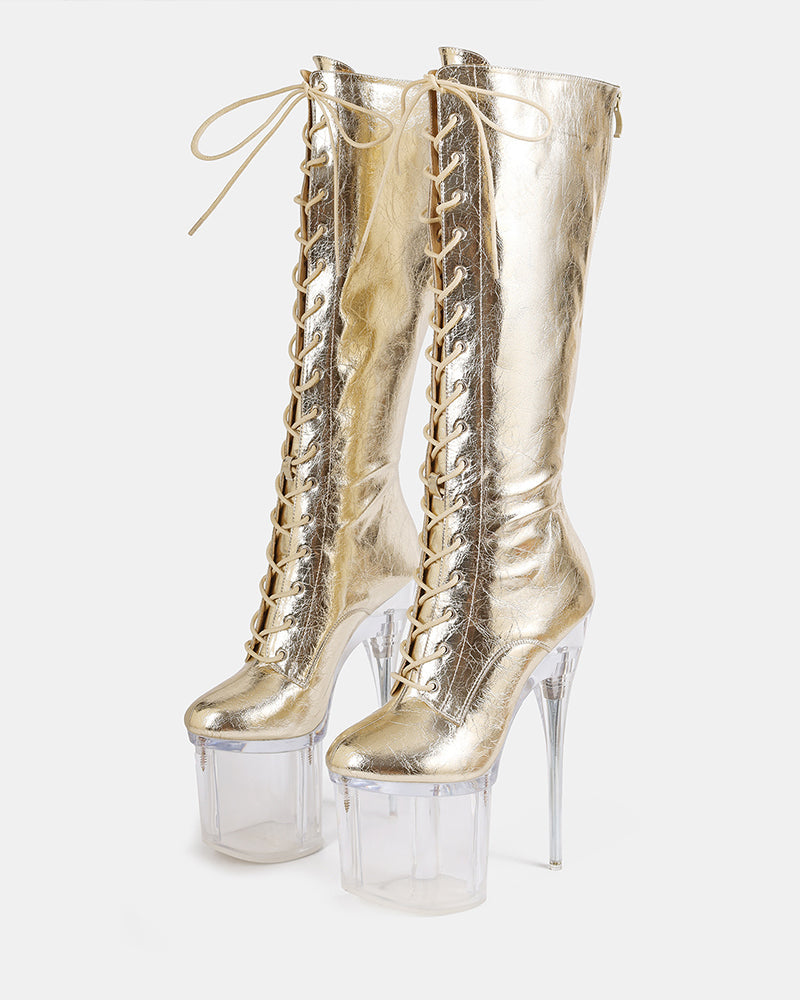 Gold metallic knee-high lace-up stiletto boots with clear platform heels, front view