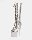 Gold metallic knee-high lace-up stiletto boot with clear platform heel, angled view