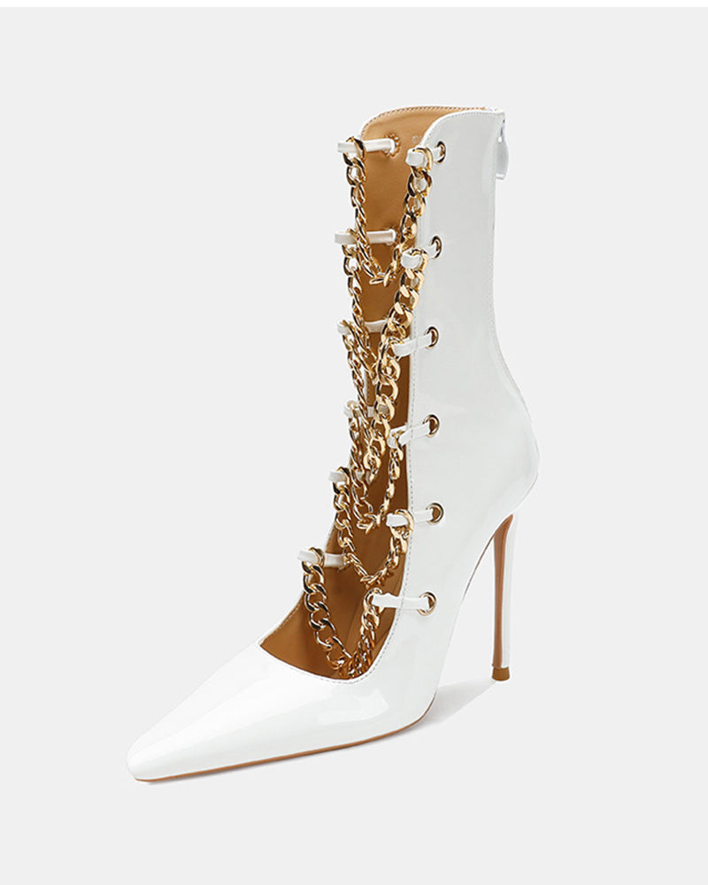 White patent stiletto ankle boot with gold chain front and tapered toe.