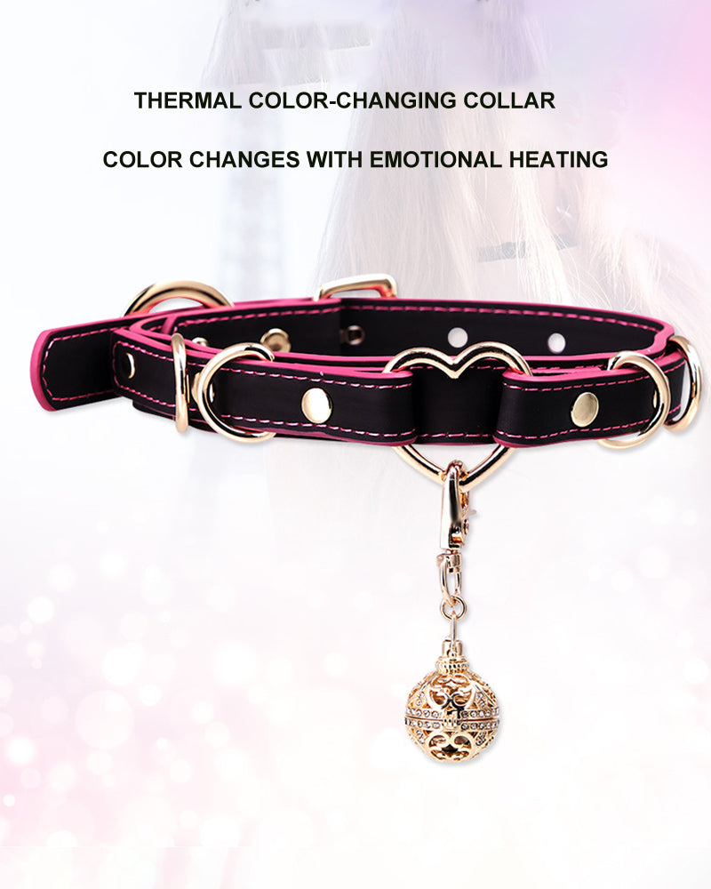 Heart-shaped leather dog collar with pink interior, metal grommets, and bell pendant charm