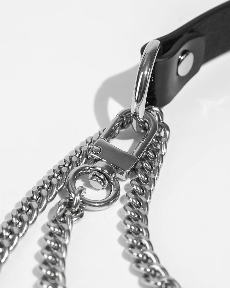 Black leather strap with shiny metal clasp and layered silver chains