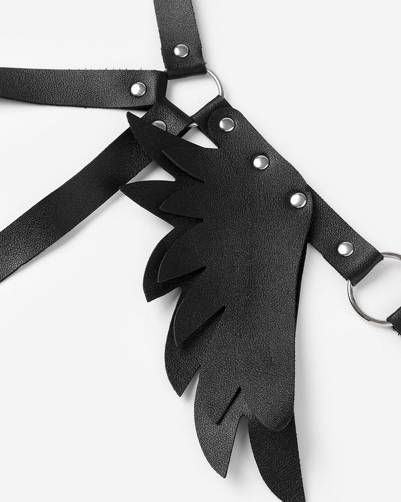 Black leather wing harness detail with studs, straps, and wing-shaped panels