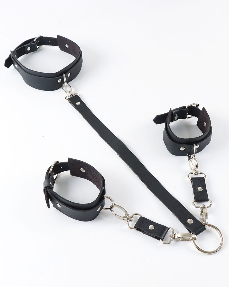 Black leather wrist cuffs, collar, and back straps set with silver buckles