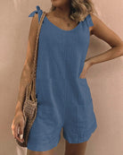 Sleeveless blue pocket shorts jumpsuit with bow shoulder ties and side pockets