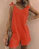 Sleeveless red pocket shorts jumpsuit with bow shoulder ties and side pockets