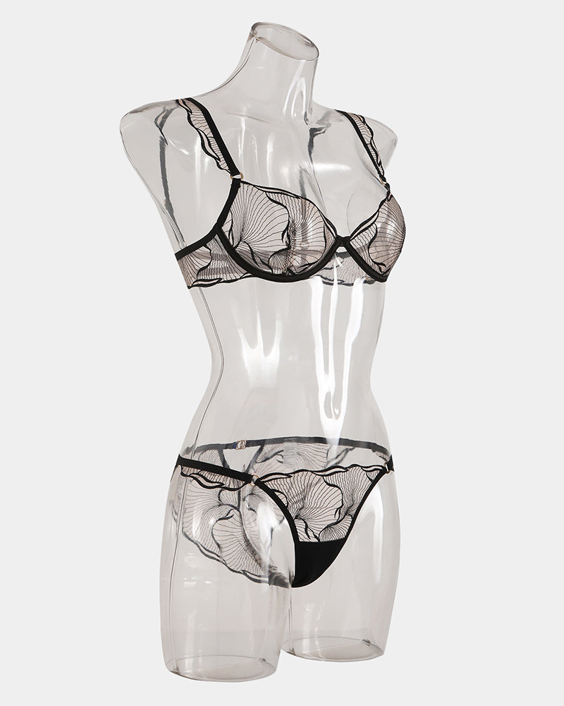 Black lace bra and panty set on mannequin with scalloped trim at bust and hips