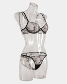 Black lace bra and panty set on mannequin with scalloped trim at bust and hips