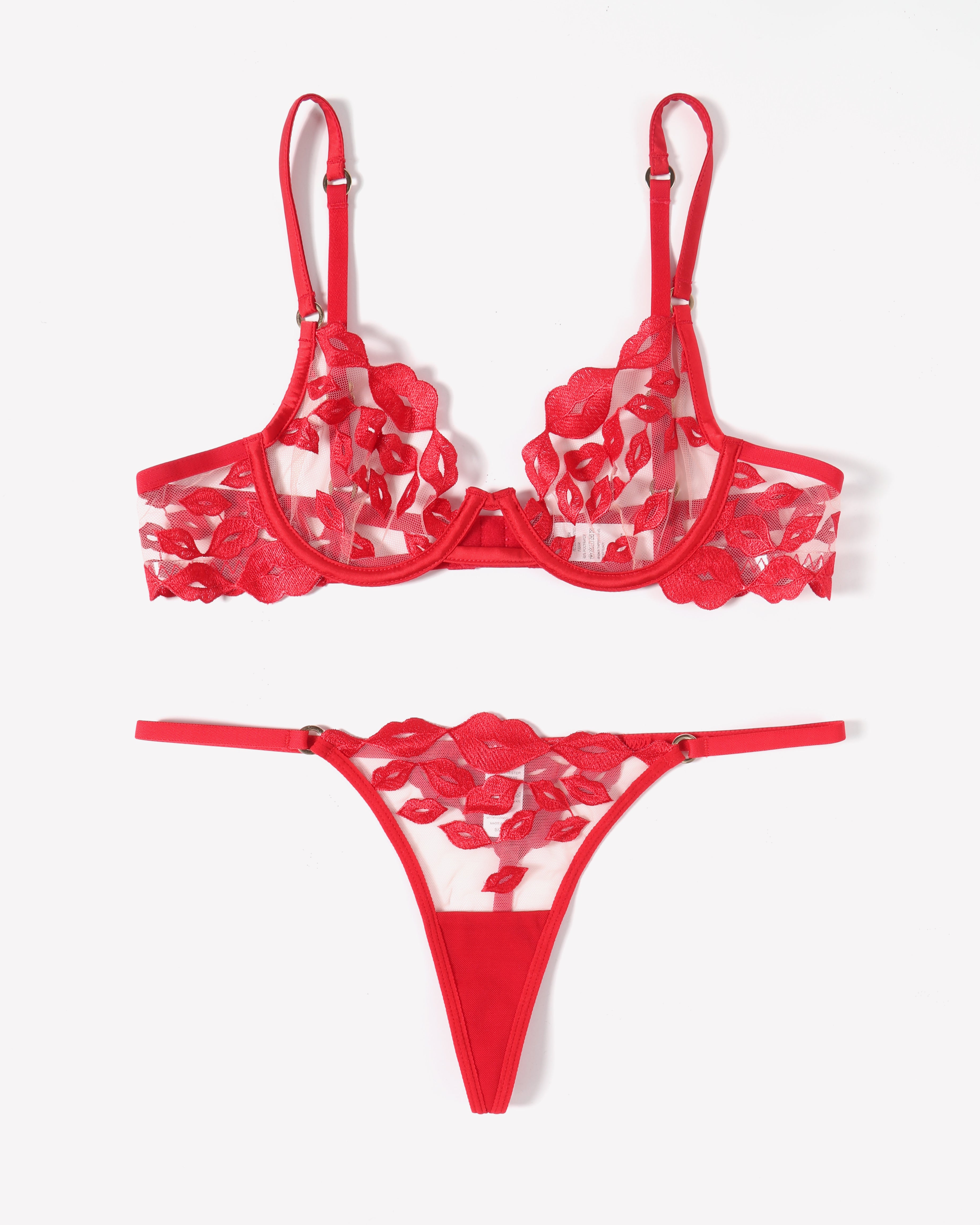 Red lace bra with kiss-print embroidery, adjustable garter straps, and matching thong