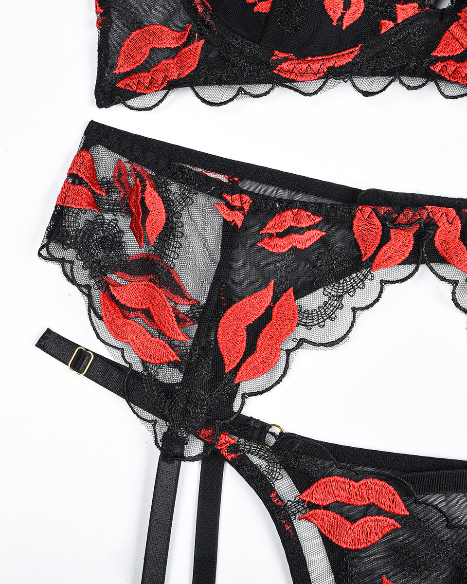Close-up of black lace garter belt with red lip print, scalloped edging and adjustable strap
