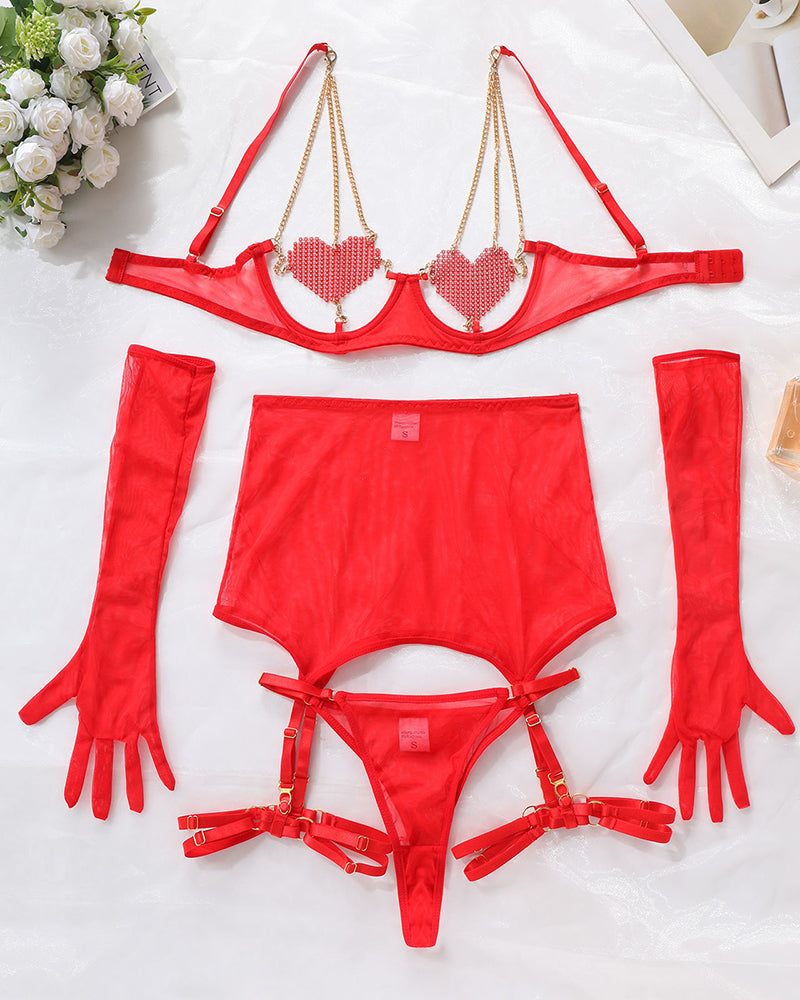 Red lingerie set flat lay: heart chain bra, panties, thigh garters, gloves