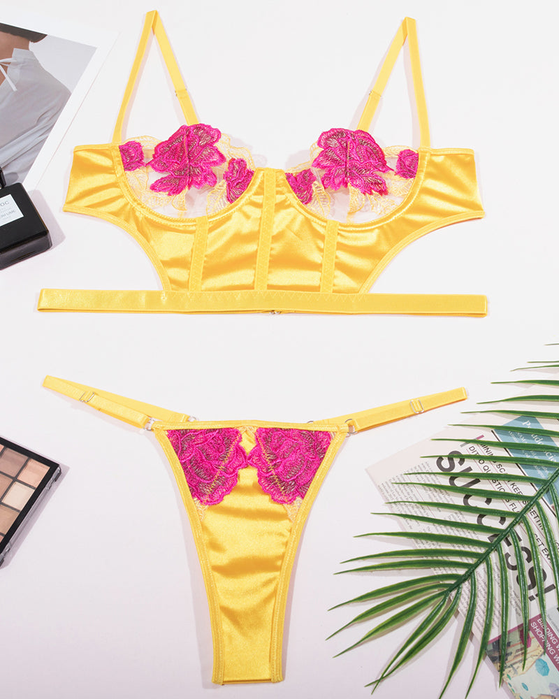 Flat lay lingerie set: yellow satin underwire bra and thong with fuchsia rose lace