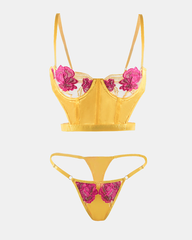 Flat lay yellow satin bra and thong set with fuchsia rose lace embroidery