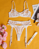 White sheer lace lingerie set: underwire bra, thong, and matching garter belt straps.