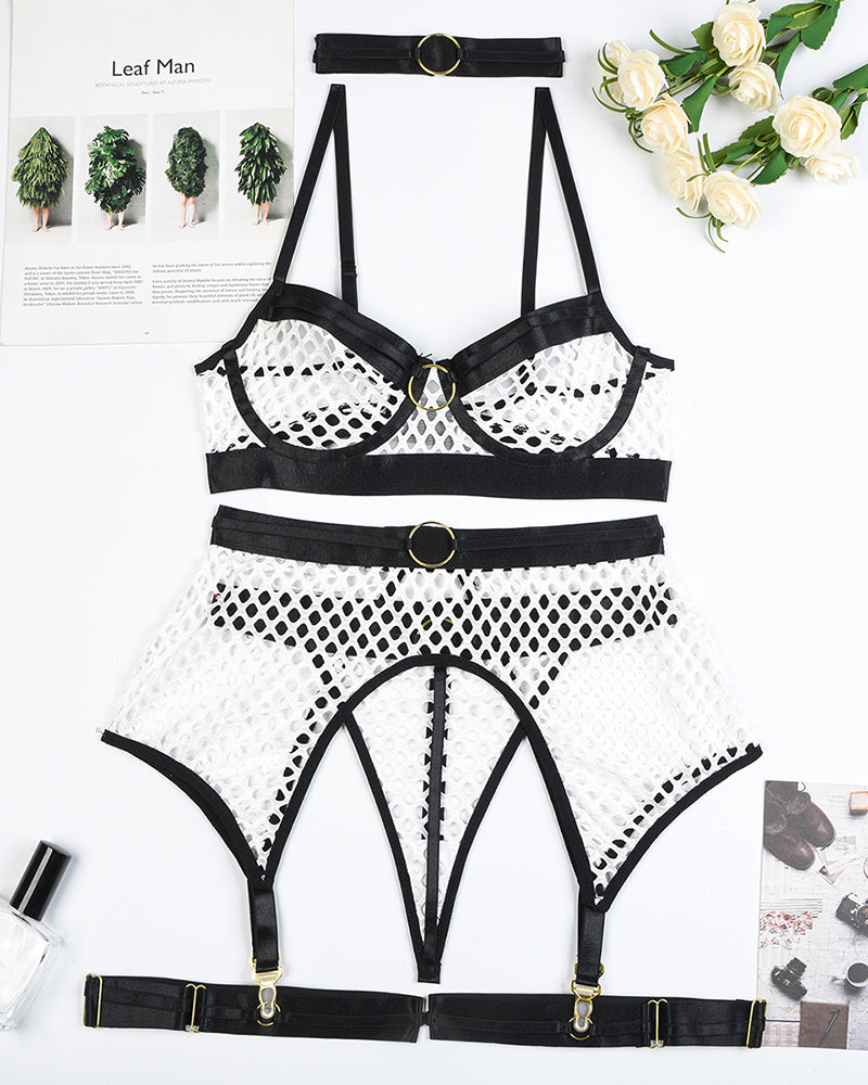 White fishnet bra and panty with garter belt straps and black trim, flat lay