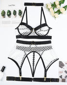 White fishnet bra and panty with garter belt straps and black trim, flat lay