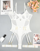 White lingerie bodysuit set with garter straps laid flat with matching harness pieces