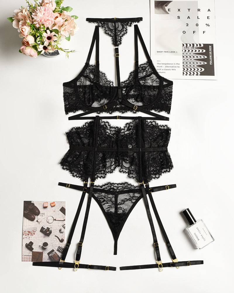 Black lace bra and panty set with garter belt, pieces laid flat