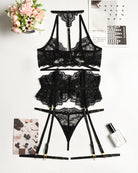 Black lace bra and panty set with garter belt, pieces laid flat
